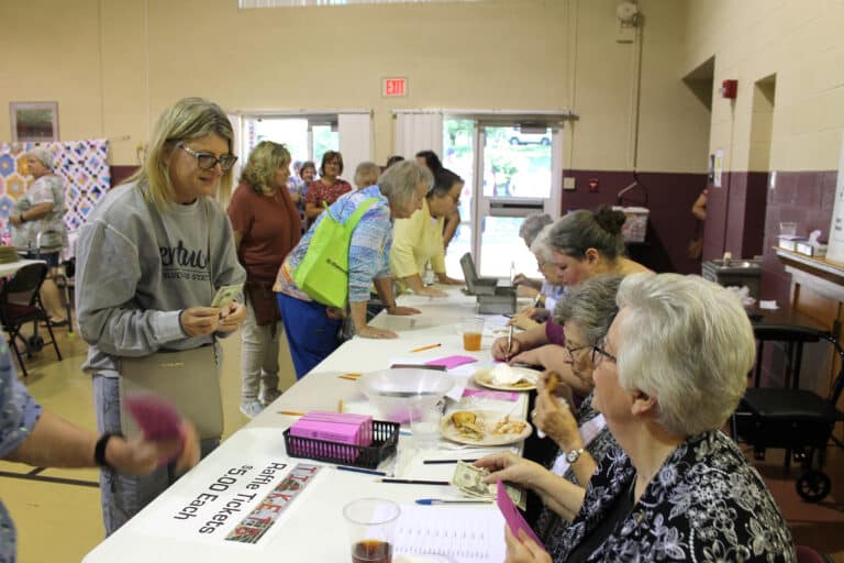 A woman prepares to purchase raffle tickets from Sister Mary Timothy Bland, right, and Sister Margaret Ann Aull.