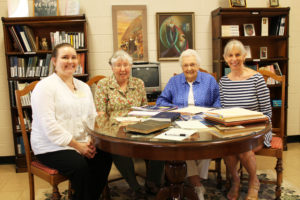 Rebecca Rolfes, right, who is writing a book about her grandmother, Mary Willie Wight, sits in the Saint Angela Oratory on June 17 as information from the archives is spread out before her. To her right (from right to left) is her mother, Lucy Thomason, Sister Ruth Gehres and Heidi Taylor-Caudill, archivist for the Ursuline Sisters.
