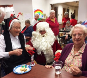 Sister Joseph Angela Boone, left, and Sister Eva Boone share cookies with Santa.