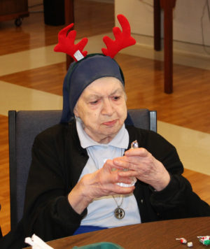 Sister Marie William Blyth studies the ornament she received from Santa, and decides whether to join in any reindeer games.