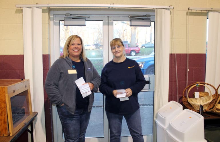 Rachel Phillips, left, and Dee Dee Jackson are ready to hand out flyers at the door that explain how to remove the bottom tag on items people wish to purchase. They work in Human Resources for the Ursuline Sisters.