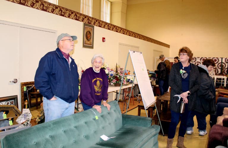 Sister Elaine Burke, second from left, enjoys talking to Eddie Tichenor at the sale, along with Coordinator of Ursuline Partnerships Doreen Abbott, right.