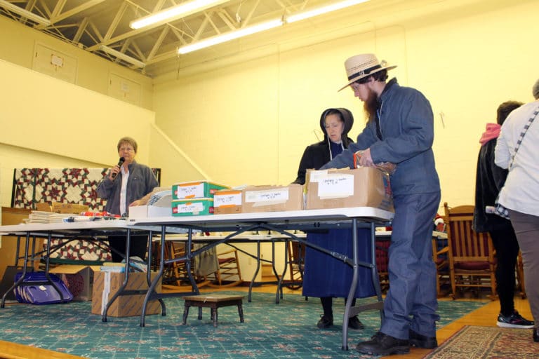 Some of the Mennonite people from the area browse through sale items. At left is Sister Amelia Stenger who periodically made announcements, such as reminding people to visit the Gift Shop.