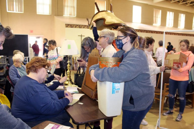 Tammy Vernon Brown with the Ursuline Sisters’ Finance office, left, helps check out people who found several items they liked.