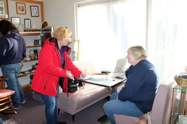 Director of Development Carol Braden-Clarke, right, sells a Quilt Club ticket to a visitor in the Gift Shop. One $25 ticket gives someone 12 chances to win a handmade quilt, with drawings taking place once a month.