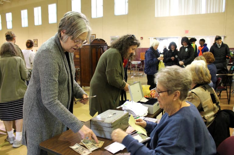 Paula Chandler Gray, an Academy alum from the Class of 1973, makes a purchase at the sale with help from Sister Betsy Moyer. In the background, Sister Vivian Bowles talks to two of the Passionist Sisters from Whitesville, Ky.