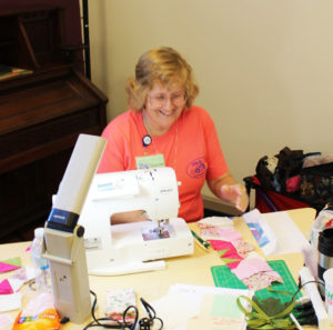 Sharon Metzger smiles as she looks over the pieces to her “I Heart Dogwoods” quilt.