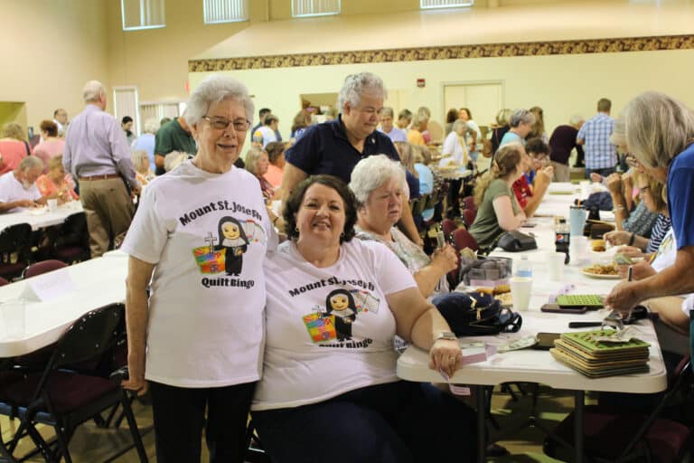 Sister Nancy Murphy, left, stands beside Mary Jane Tungate, her former student. Mary Jane gave Sister Nancy a T-shirt to wear at the Ursuline Sisters’ Quilt Bingo.