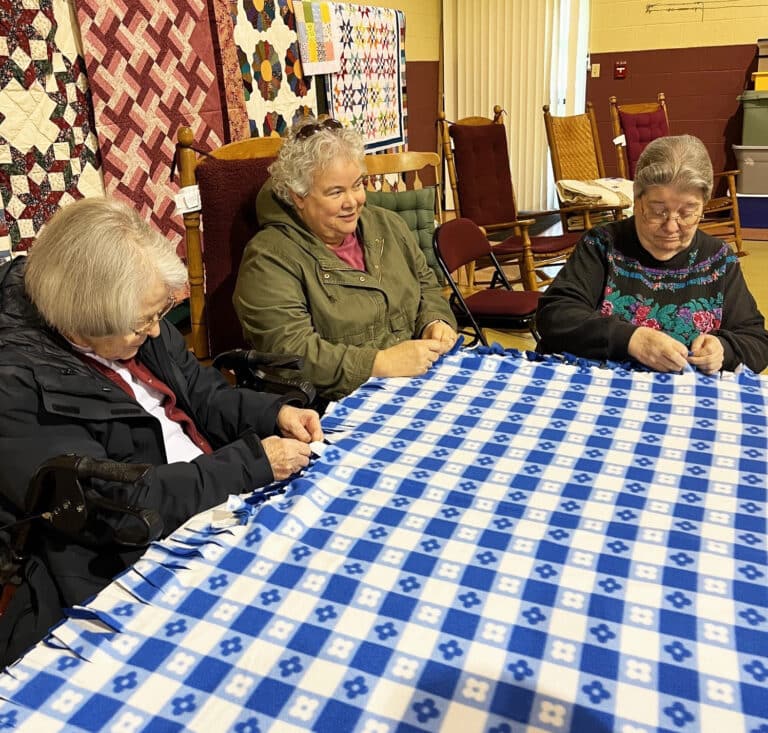 Sister Martha Keller, center, assistant congregational leader, joins Sister Catherine Barber, left, and Sister Rose Jean Powers on this blue and white blanket.