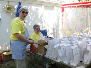 Sister Rose Jean, seated, works “behind the curtain” at the Fish Pond with Sister Julia Head during the 2010 Mount Saint Joseph Picnic to benefit the retired Ursuline Sisters.