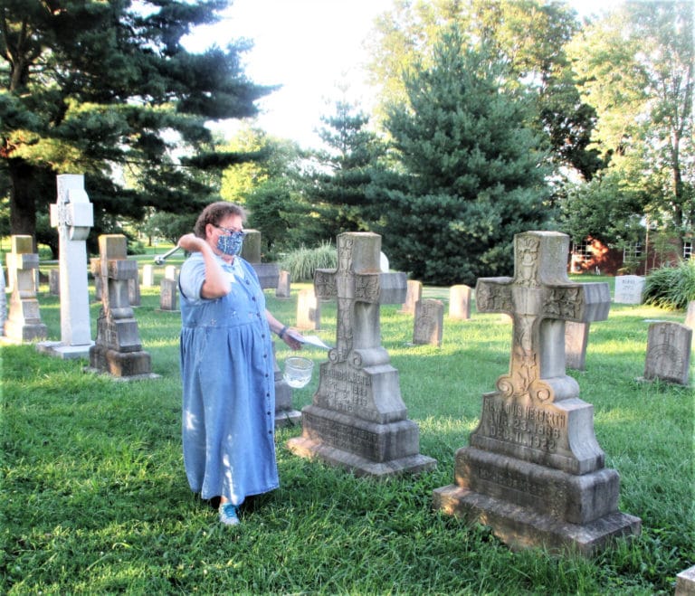 Sister Alicia Coomes, director of local community life, blesses the graves of all those sisters, priests and other companions who paved the way for today’s Ursuline Sisters.
