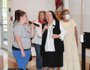 Sister Catherine Marie Lauterwasser, center, sings “Somewhere Over the Rainbow” with Melissa Hayden, left, during karaoke in Saint Joseph Villa on xx, 2014. Erin Mills, second from left, and Jan Gish, right, serve as back-up singers.