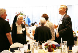 Sister Mary Timothy Bland, left, and Sister Joseph Angela Boone, center, smile at a comment made by Mark Pfeifer, right.
