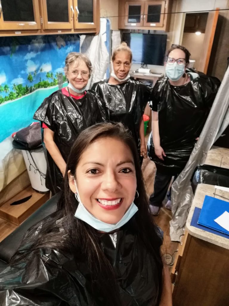 When the rain comes unexpectantly along the border, the staff of Global Response Management improvise with trash bags as raincoats. Sister Jacinta, back left, is joined by women who are part of the staff at the clinic who are also asylum seekers