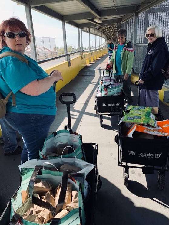 Sister Jacinta Powers, center, prepares to walk a wagon of supplies across the International Bridge from Brownsville, Texas, to Matamoros, Mexico.