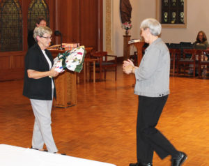 Sister Julia Head, right, prepares to receive her quilt from her longtime friend Sister Judith Nell Riney.