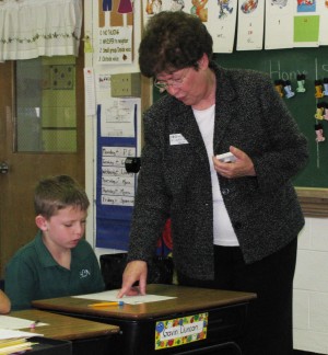 Sister Laurita Spalding helps a second-grade student with a math problem at Holy Name School in Henderson, Ky. in 2011.