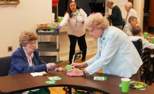 Sister Mary Patrick McDonagh, left, the only Ursuline Sister who hails from Ireland, gets a shamrock with a number on it from Sister Mary Sheila Higdon. The numbers were for door prizes during the party.
