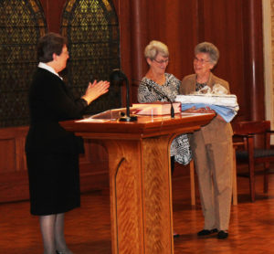 Following her reflection on how Saint Angela called all of us to “be like a piazza, open to all,” Sister Amelia Stenger surprised the outgoing Council with their own quilt. Here, Sister Amelia, left, and Sister Pam Mueller, center, present a quilt to Sister Nancy Murphy.