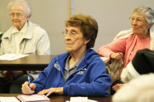 Ursuline Sister Elaine Burke, center, makes note of Sister Vivian’s comments about the importance of affirmations, as Sisters Alfreda Malone, left, and Marietta Wethington look on.