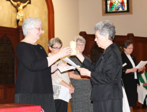 Each member of the 2010-16 Council passed on her lighted candle to her counterpart on the 2016-22 Council, as a way to transfer the light for the future. Here, Sister Nancy Murphy, right, gives her candle to Sister Pat Lynch.