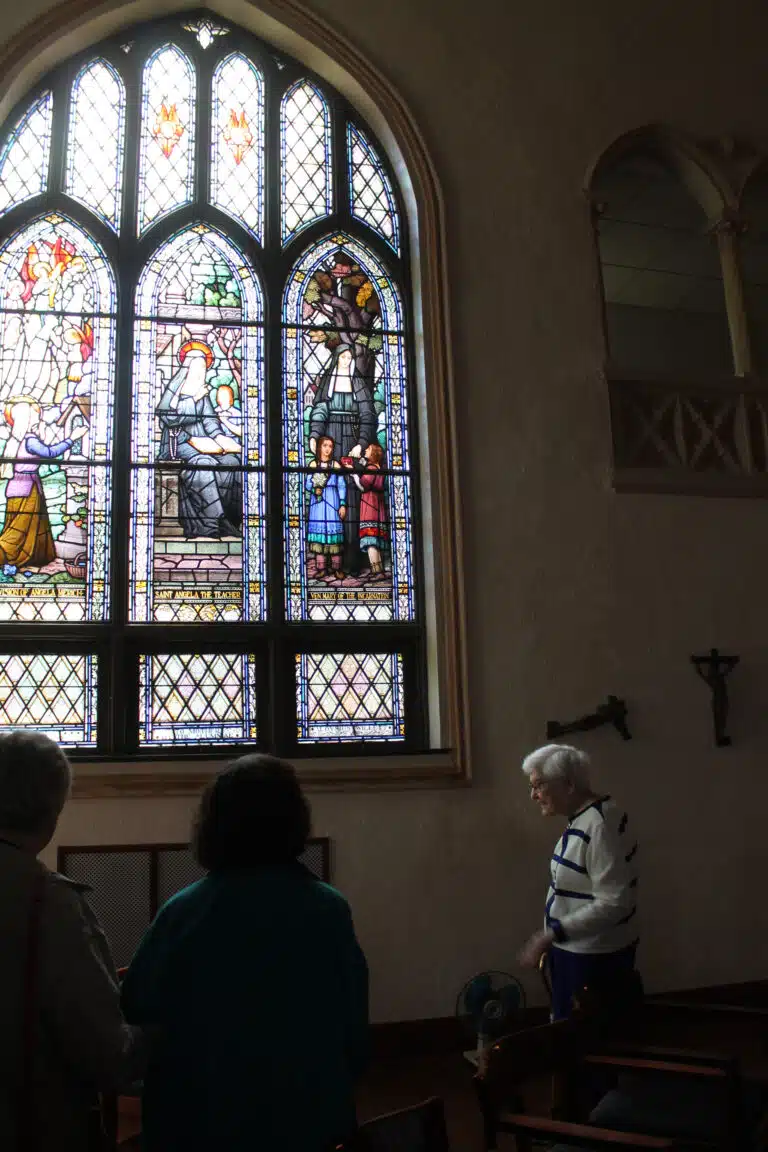 Sister George Mary Hagan tells visitors about the beautiful stained-glass windows in the Chapel, including this one featuring Saint Angela Merici, founder of the Ursuline order. Sister George Mary Hagan tells visitors about the beautiful stained-glass windows in the Chapel, including this one featuring Saint Angela Merici, founder of the Ursuline order.