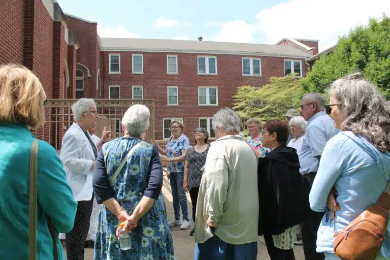 Sister Michele Morek, left, a former congregational leader, points out the piazza located beside the Motherhouse Chapel. She mentioned that the Ursuline Sisters strived to use the work of female artists, and that one artist had given them the idea for the Chapel bell tower. Sister Michele Morek, left, a former congregational leader, points out the piazza located beside the Motherhouse Chapel. She mentioned that the Ursuline Sisters strived to use the work of female artists, and that one artist had given them the idea for the Chapel bell tower.