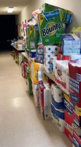 Supplies donated for tornado victims line the hall of the St. Jerome parish hall.