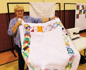 Trish Bishop holds the quilt she made for her 11-year-old granddaughter.