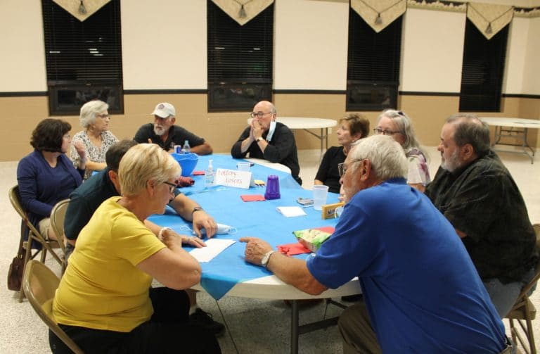 The “Lottery Losers,” including Father Pat Reynolds, center, ponder possible answers as they play trivia.