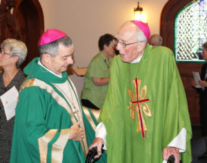 Bishop William Medley, left, bishop of the Diocese of Owensboro, shares a laugh with his predecessor, Bishop Emeritus John McRaith, before Mass began.
