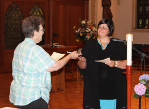 Sister Stephany Nelson, right, receives a copy of the Ursuline Way of Life from Sister Sharon Sullivan, congregational leader, during her Rite of Entrance. “May God increase your desire and willingness to live as a woman religious in this community of Ursuline Sisters of Mount Saint Joseph,” Sister Sharon said.