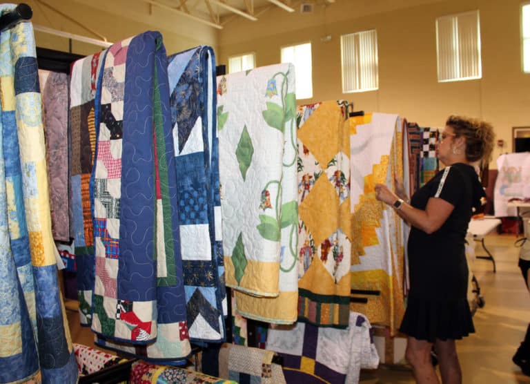 Vicky Dickens of Philpot, Ky., peruses the quilt display to pick one after winning.