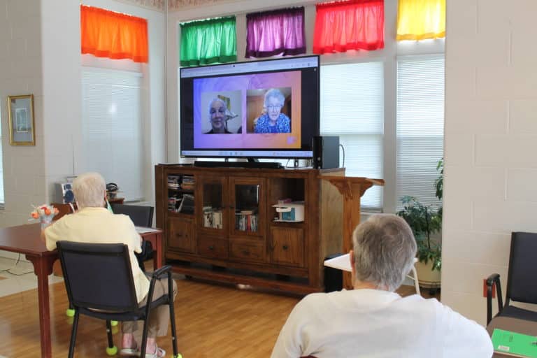 Sister Larraine Lauter, at left on the screen, listens as Sister Michele Morek says there are different ways of making a pilgrimage.
