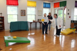 Sister Paul Marie Greenwell plays corn hole as Sister Marie Bosco Wathen and Debbie Dugger watch in the background.
