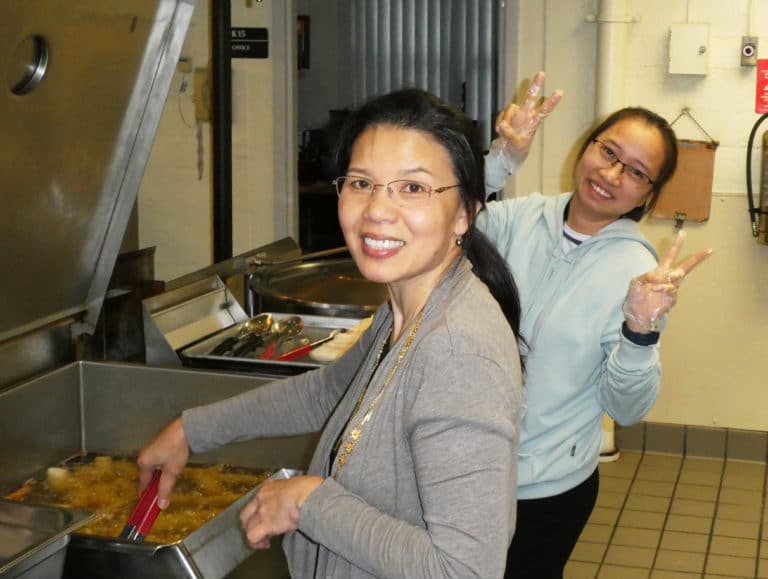 The Vietnamese sisters are famous for their egg rolls. Here, Sister Cecelia is assisted by Chi Hoang, of Evansville, Ind., left, who along with her husband, The, have been supporters of the Vietnamese sisters.